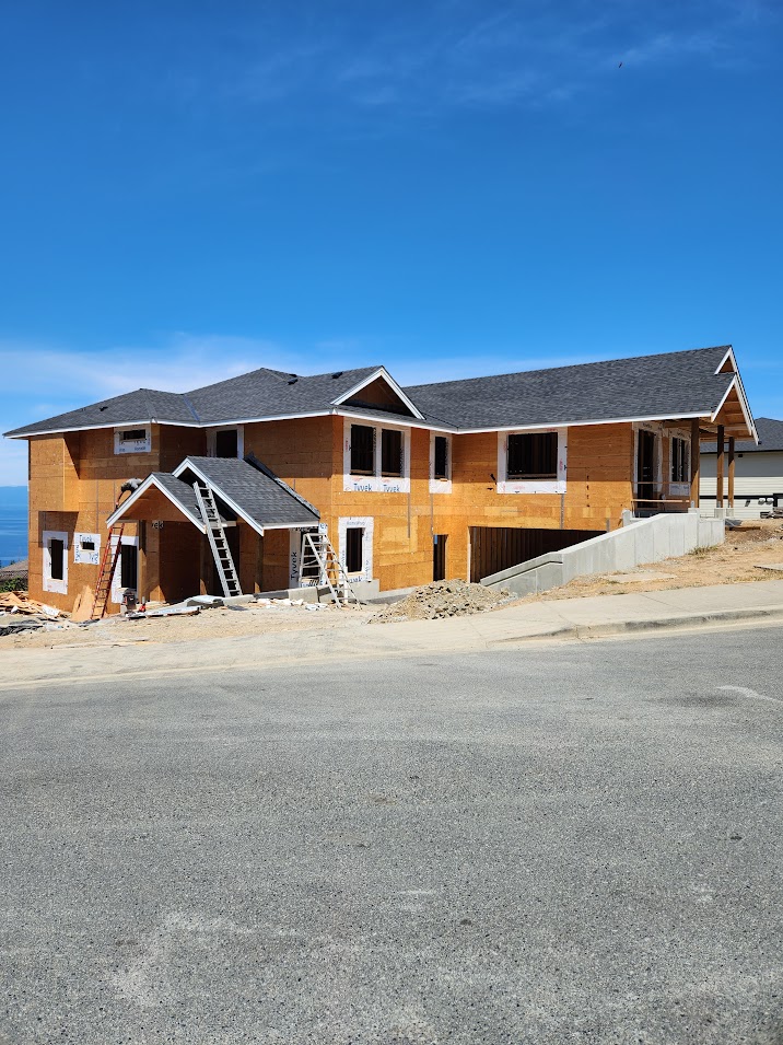 New construction home with completed shingle roof